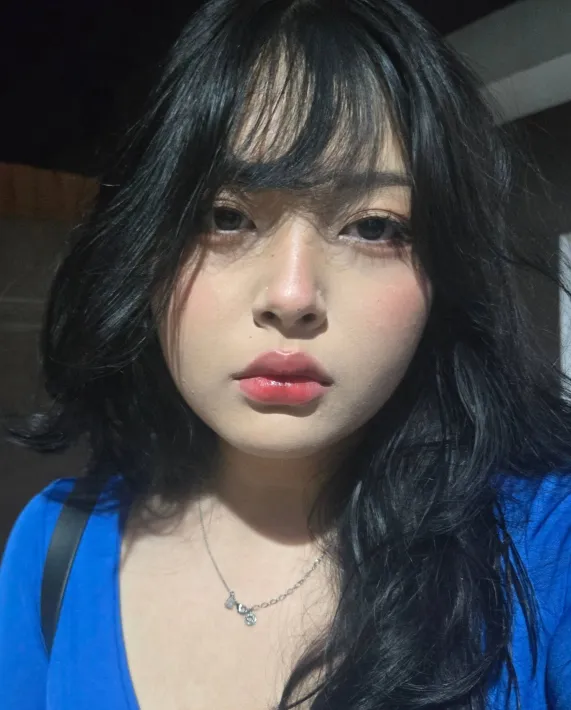 Foto de Amandha Yumi, uma menina japonesa de camiseta azul, cabelo preto com franja